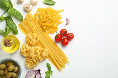 Photo of Different types of pasta, spices and products on white background, top view. Space for text