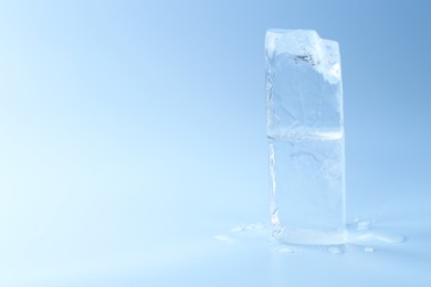 Photo of Blocks of clear ice on light blue background, space for text