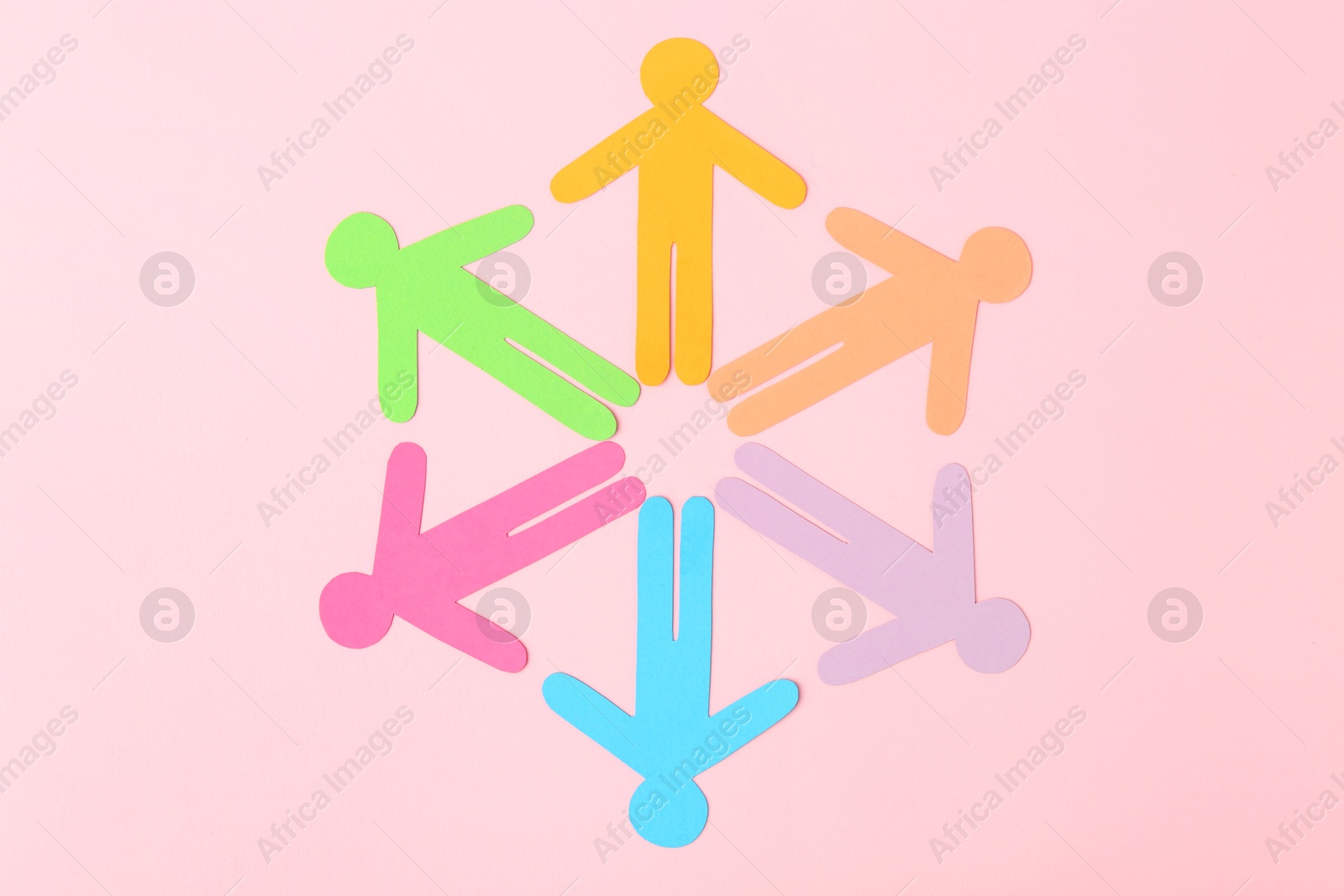 Photo of Equality concept. Paper human figures of different colors on pink background, top view