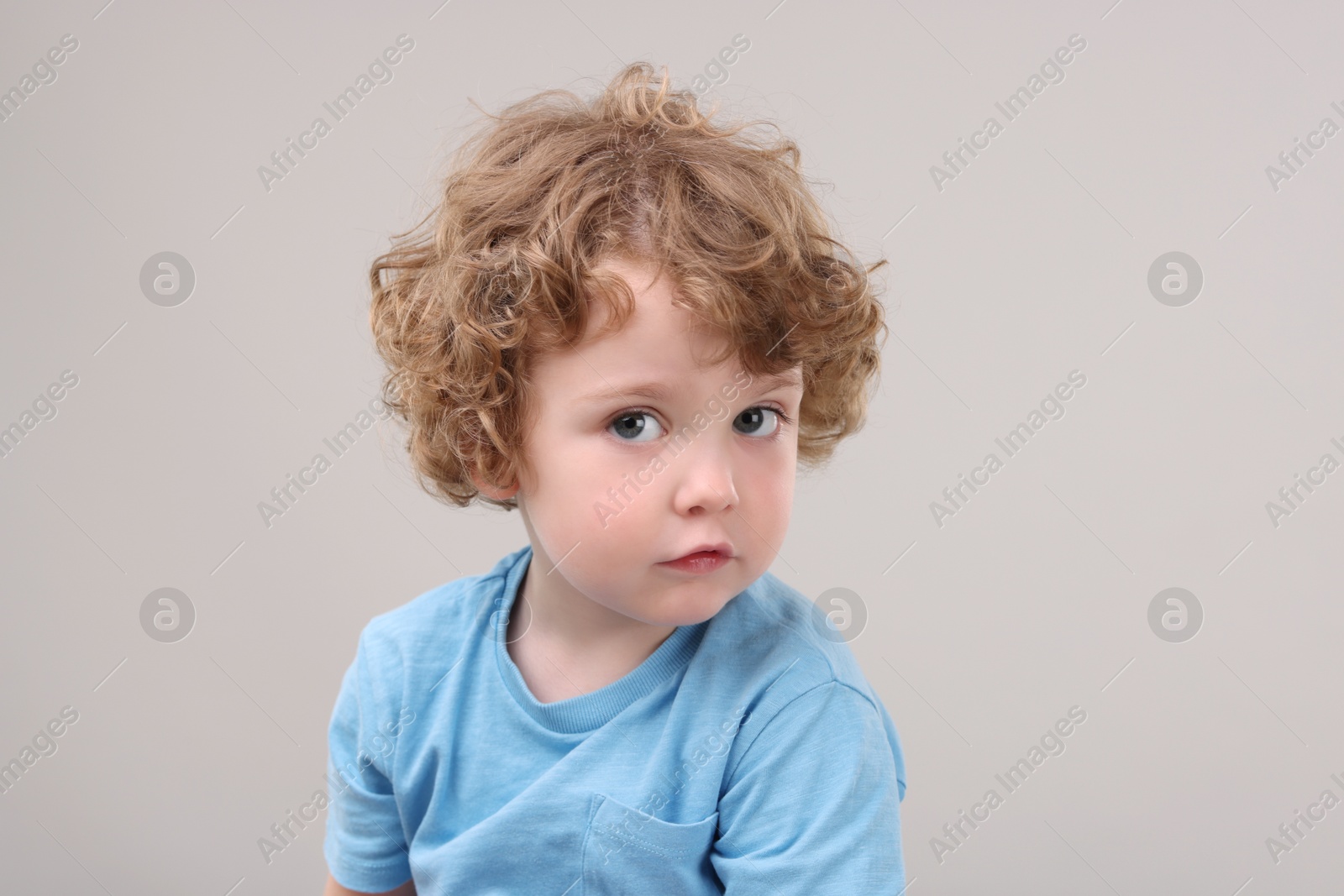 Photo of Portrait of cute little boy on grey background