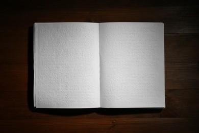 Photo of Book with Braille text on wooden table, top view. Education and leisure for blind people