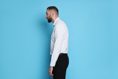 Photo of Man with poor posture on light blue background