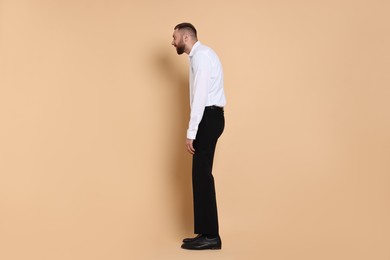 Photo of Man with poor posture on pale orange background