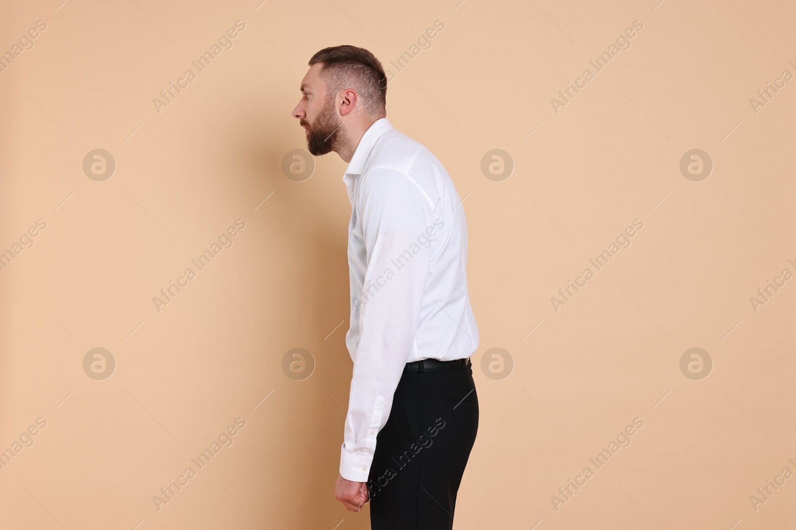 Photo of Man with poor posture on pale orange background