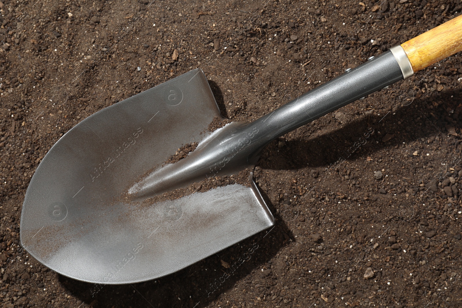 Photo of Metal shovel on pile of soil, top view