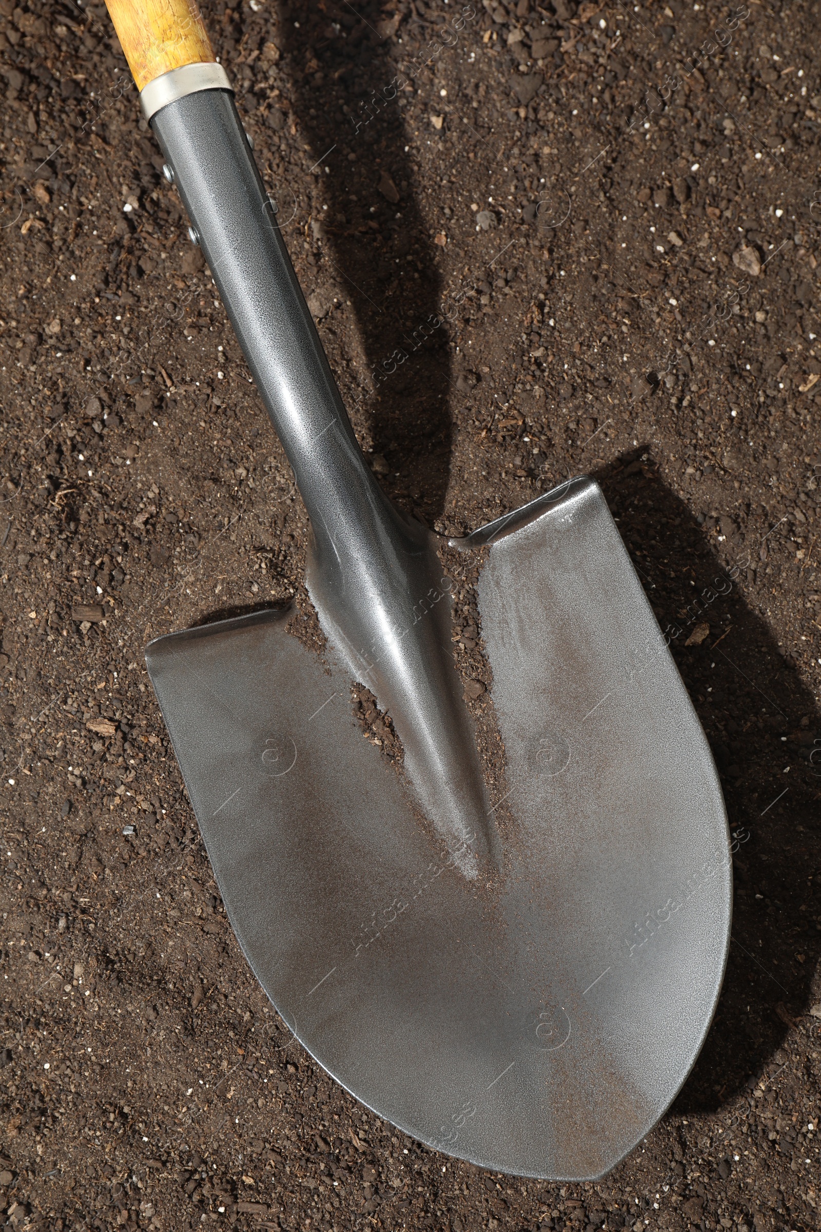 Photo of Metal shovel on pile of soil, top view