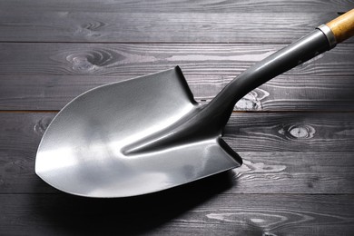 Photo of Metal shovel with handle on black wooden table