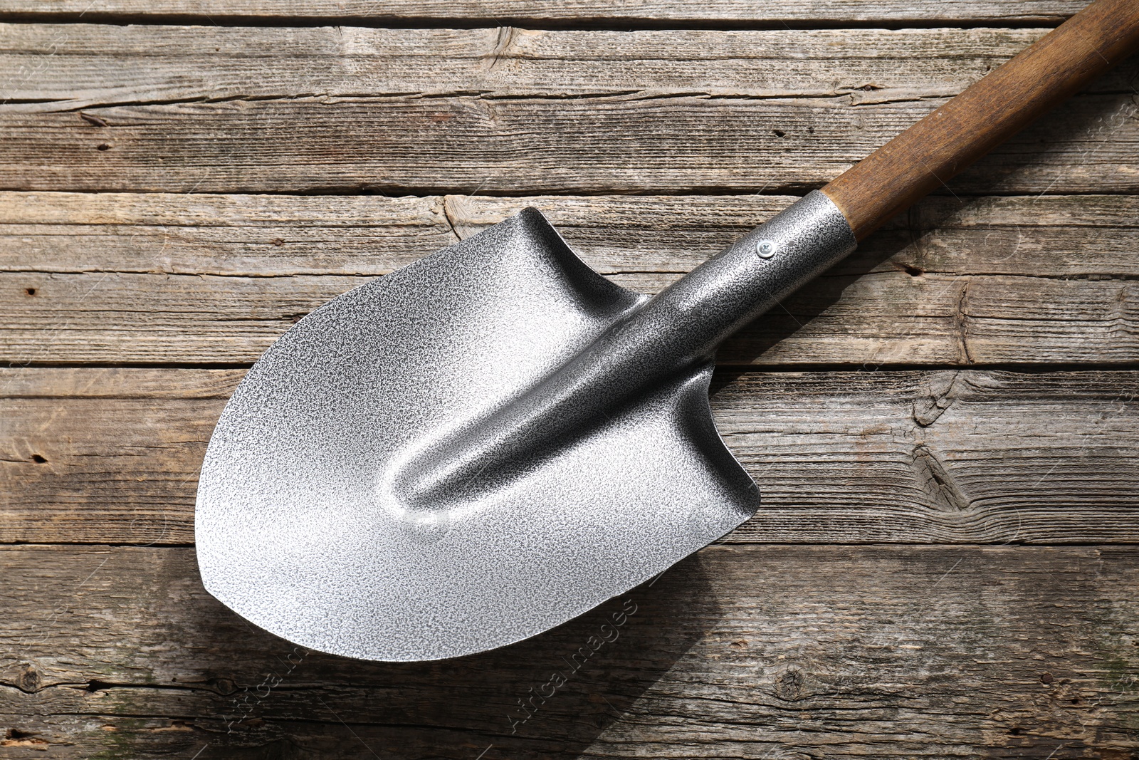 Photo of Metal shovel on wooden table, top view