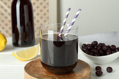 Photo of Delicious acai juice, berries and lemon on white wooden table