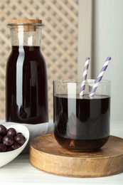 Photo of Delicious acai juice and berries on white wooden table