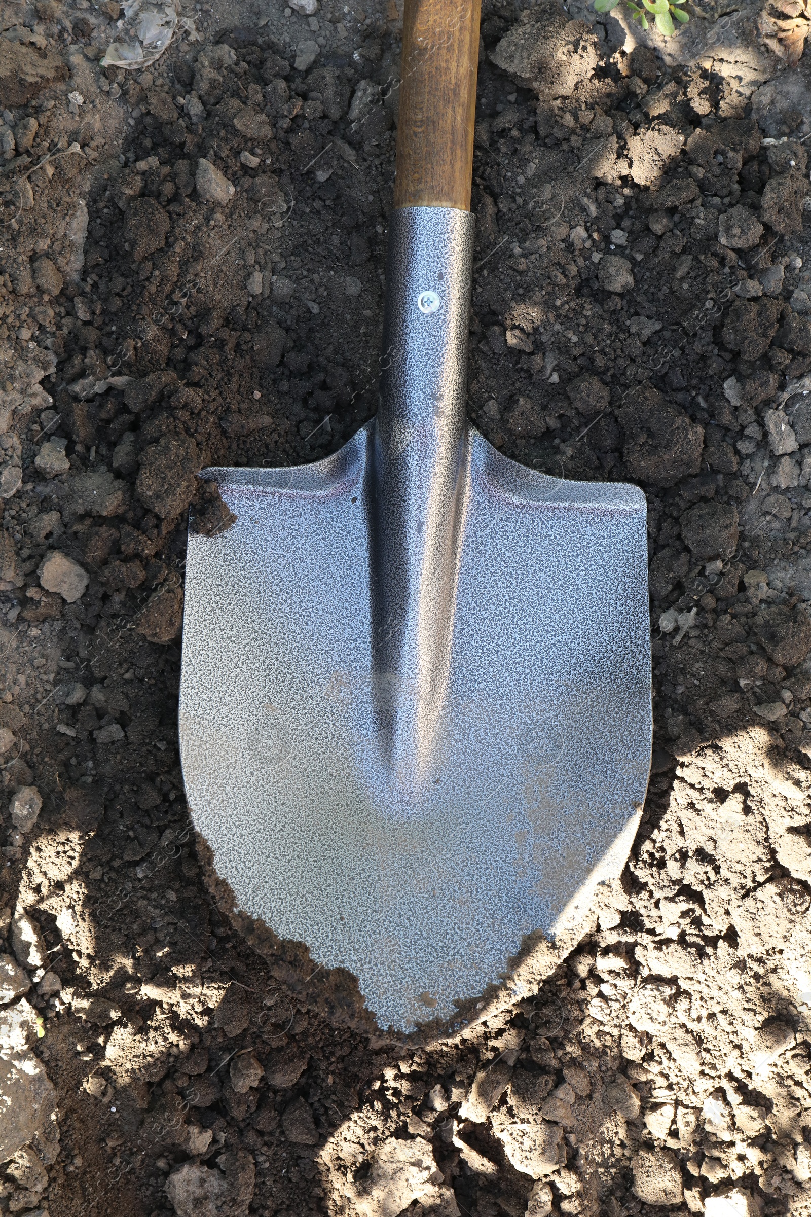 Photo of Metal shovel on soil outdoors, top view