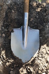 Photo of Metal shovel on soil outdoors, top view