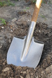 Photo of Digging soil with shovel in garden, closeup