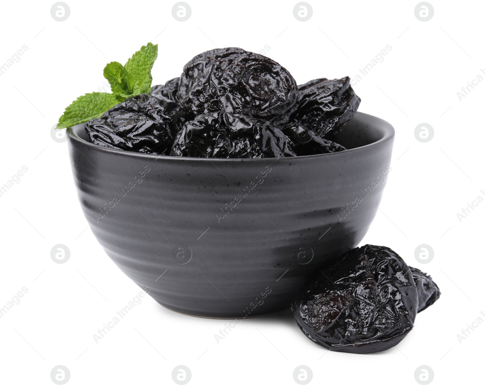 Photo of Tasty dried plums (prunes) and mint leaves in bowl on white background