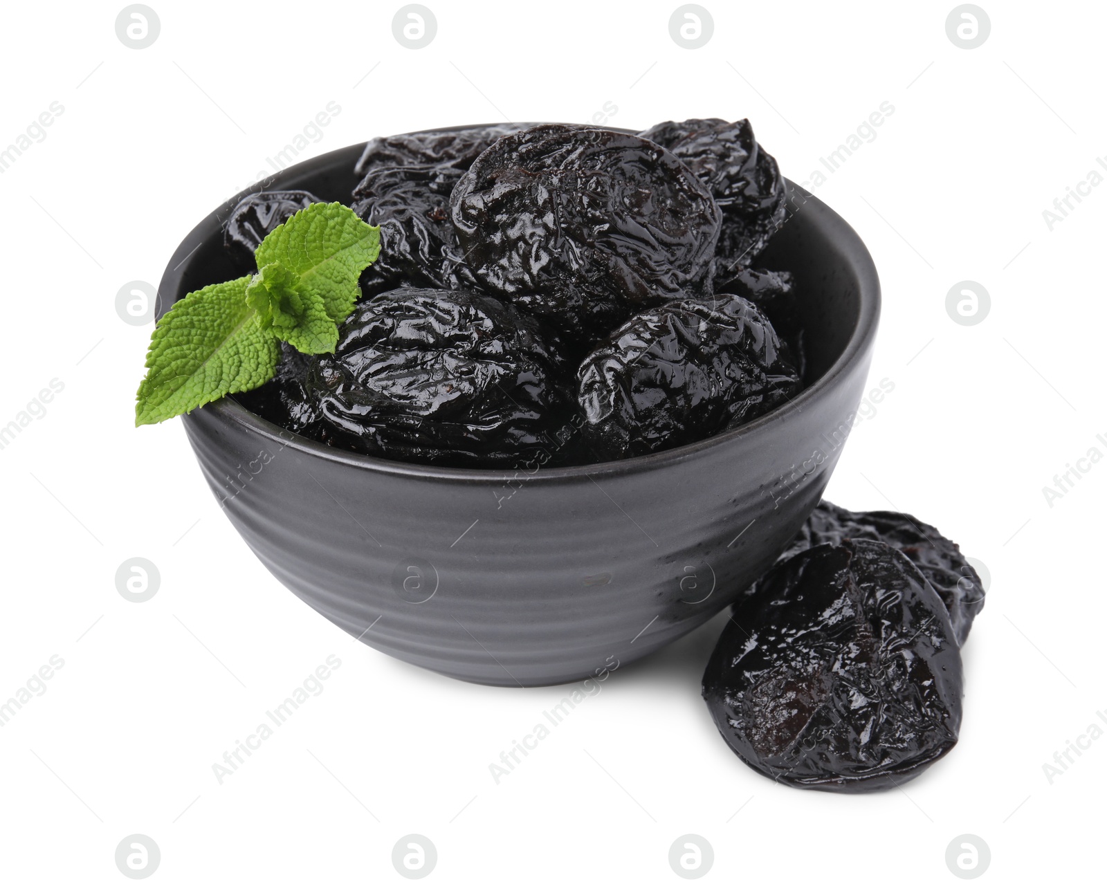 Photo of Tasty dried plums (prunes) and mint leaves in bowl on white background