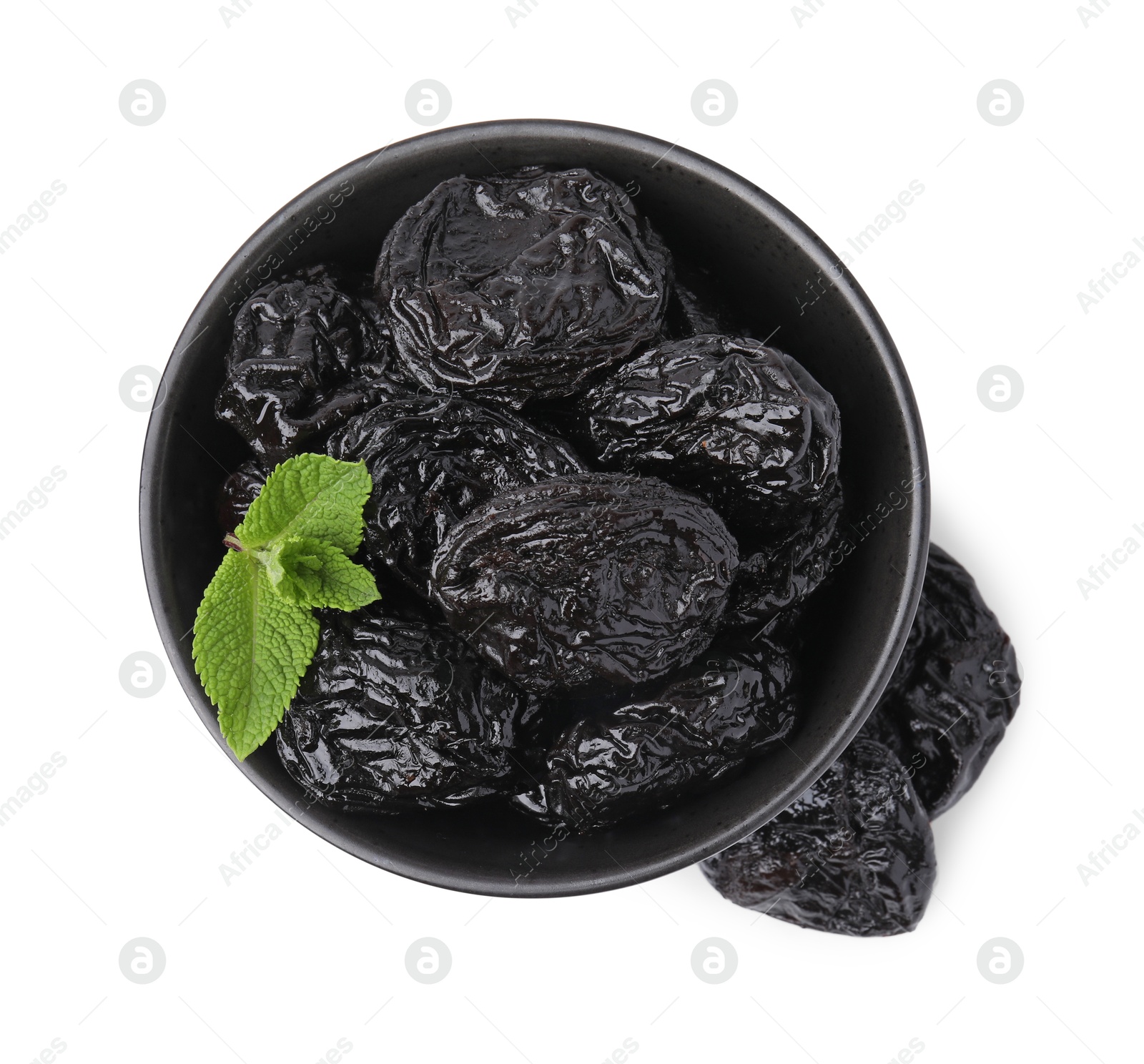 Photo of Tasty dried plums (prunes) and mint leaves in bowl on white background, top view