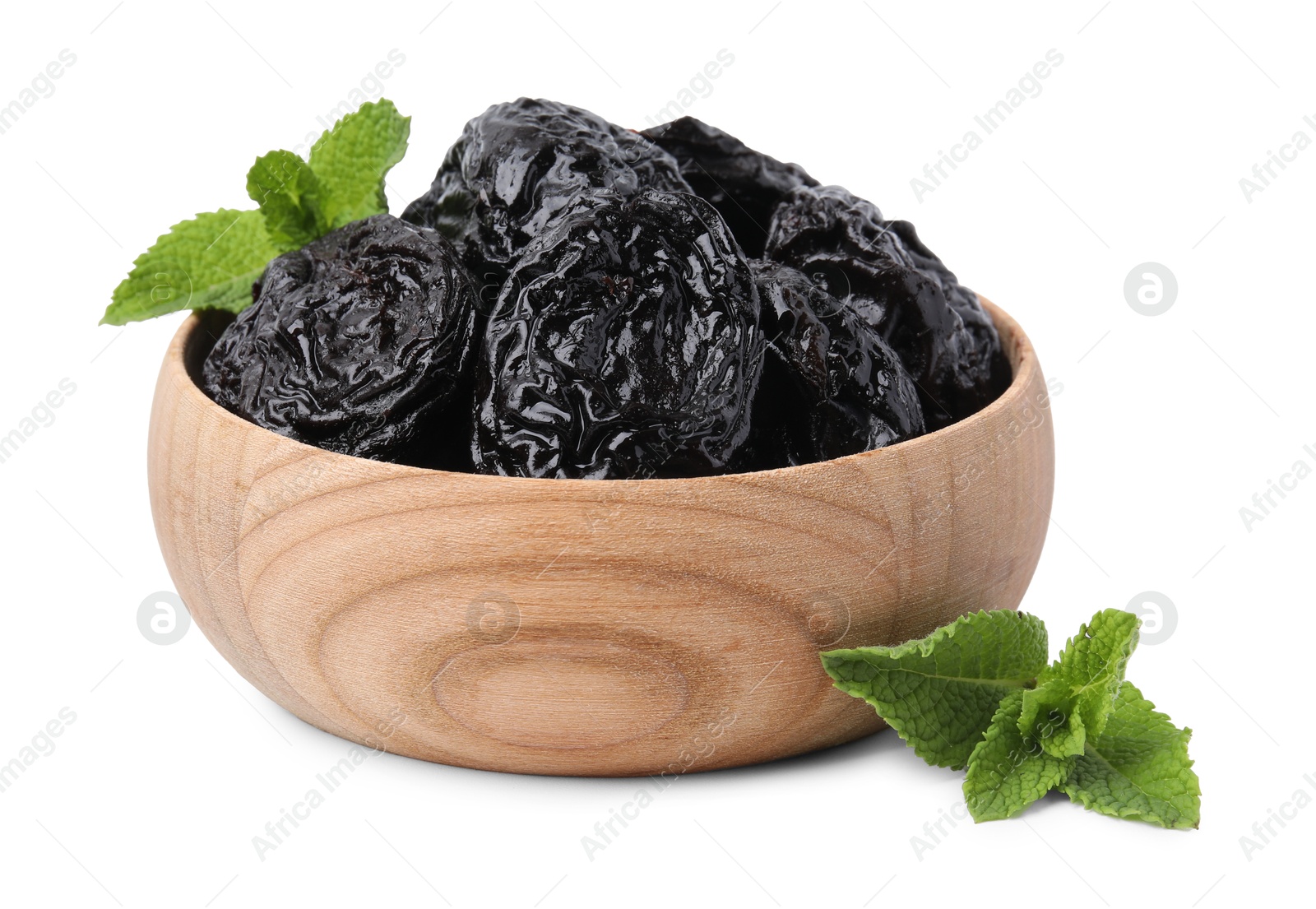 Photo of Tasty dried plums (prunes) and mint leaves in wooden bowl on white background