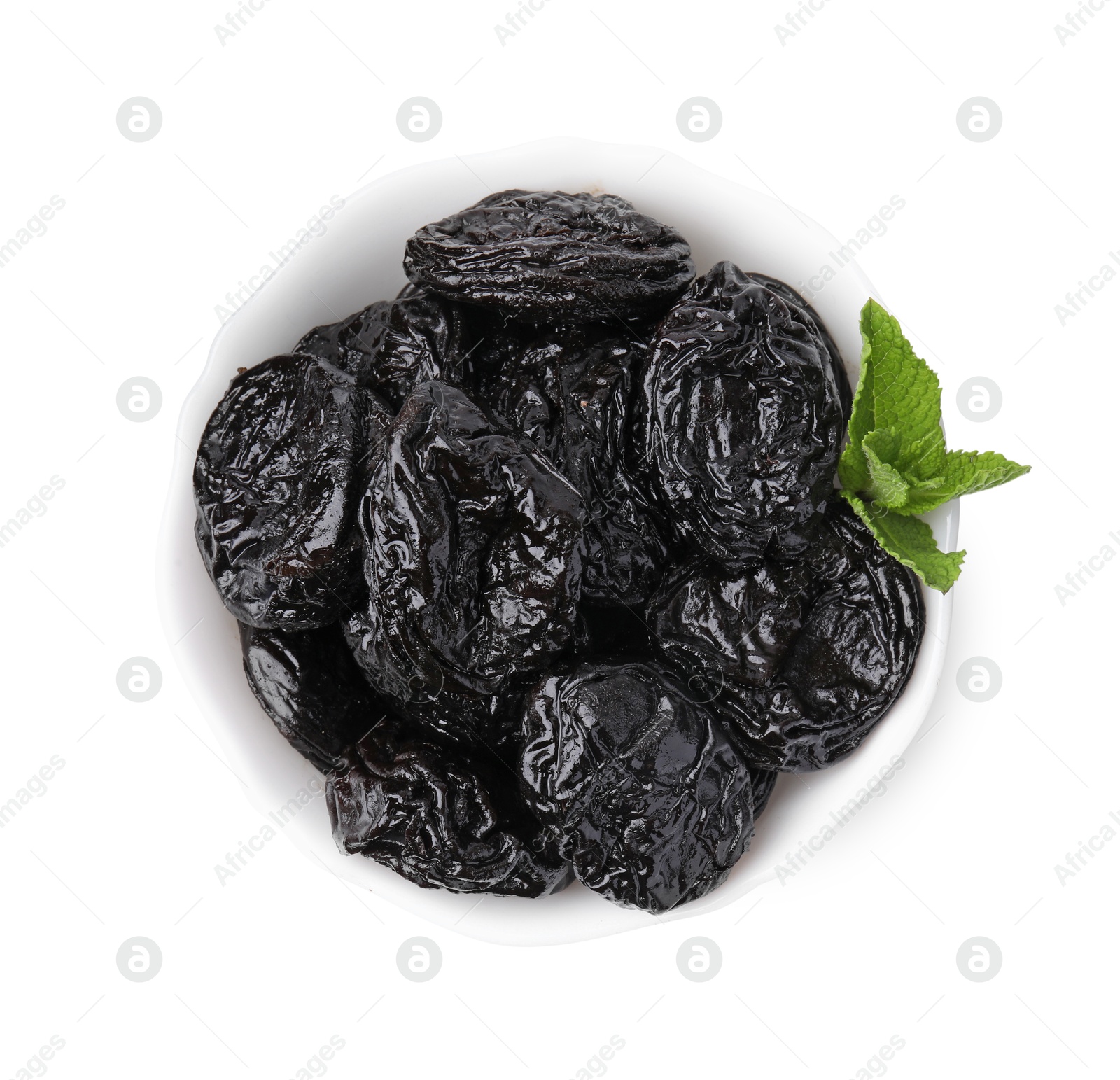 Photo of Tasty dried plums (prunes) and mint leaves in bowl on white background, top view