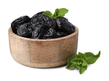 Photo of Tasty dried plums (prunes) and mint leaves in wooden bowl on white background
