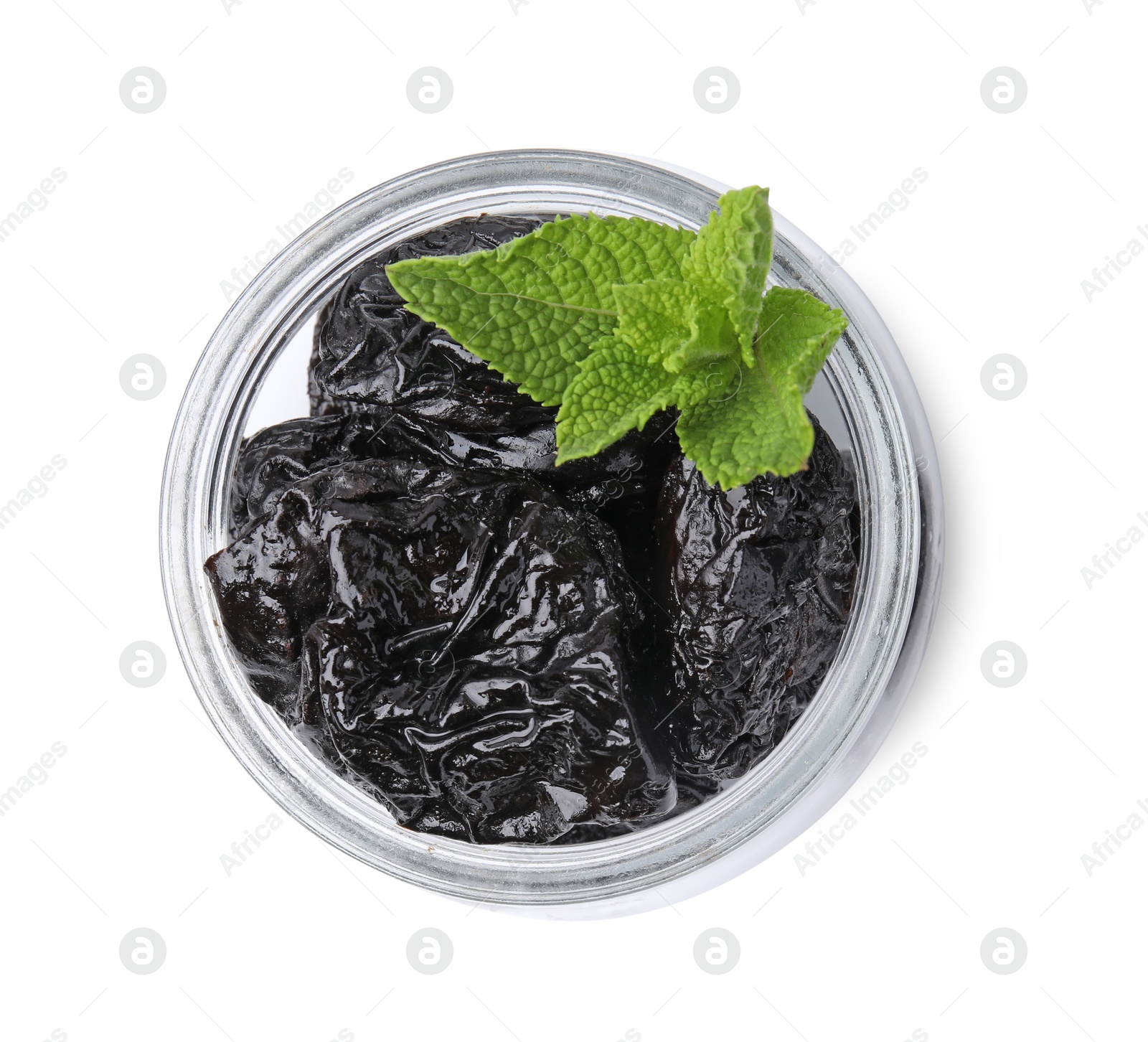 Photo of Tasty dried plums (prunes) and mint leaves in glass jar on white background, top view