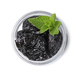 Photo of Tasty dried plums (prunes) and mint leaves in glass jar on white background, top view