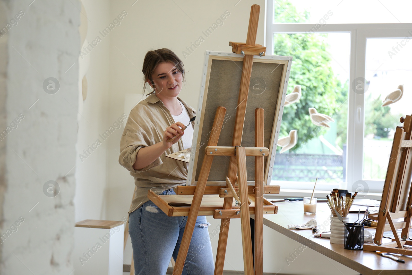 Photo of Woman with palette knife drawing picture in studio