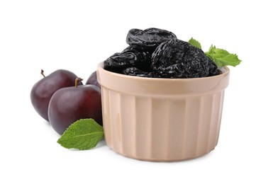 Photo of Delicious prunes in bowl, fresh ripe plums and mint isolated on white