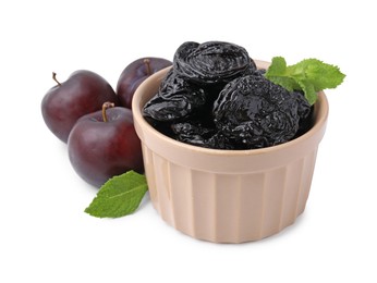 Photo of Delicious prunes in bowl, fresh ripe plums and mint isolated on white