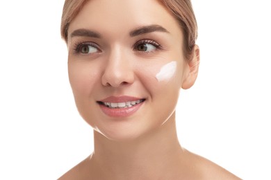 Beautiful woman with cream on her face against white background, closeup