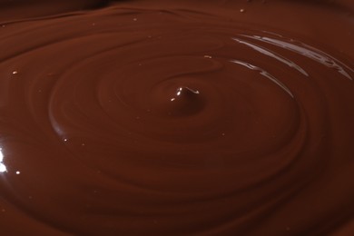 Photo of Tasty melted chocolate as background, closeup view