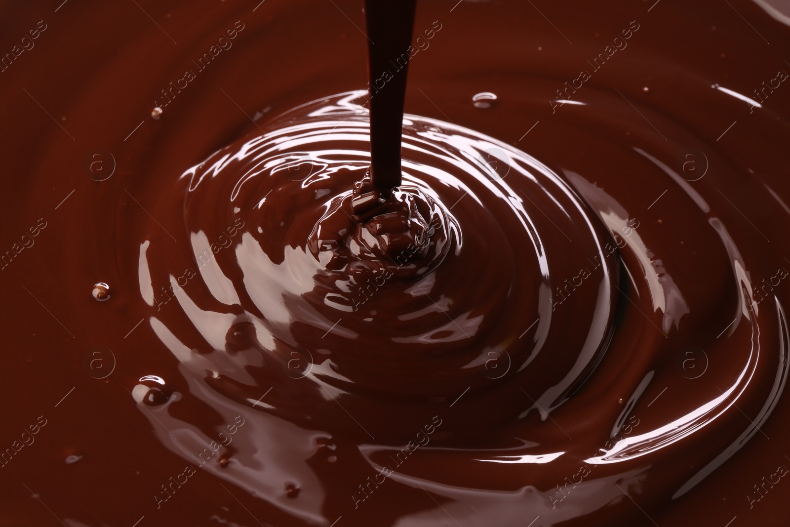 Photo of Closeup view of pouring delicious melted chocolate