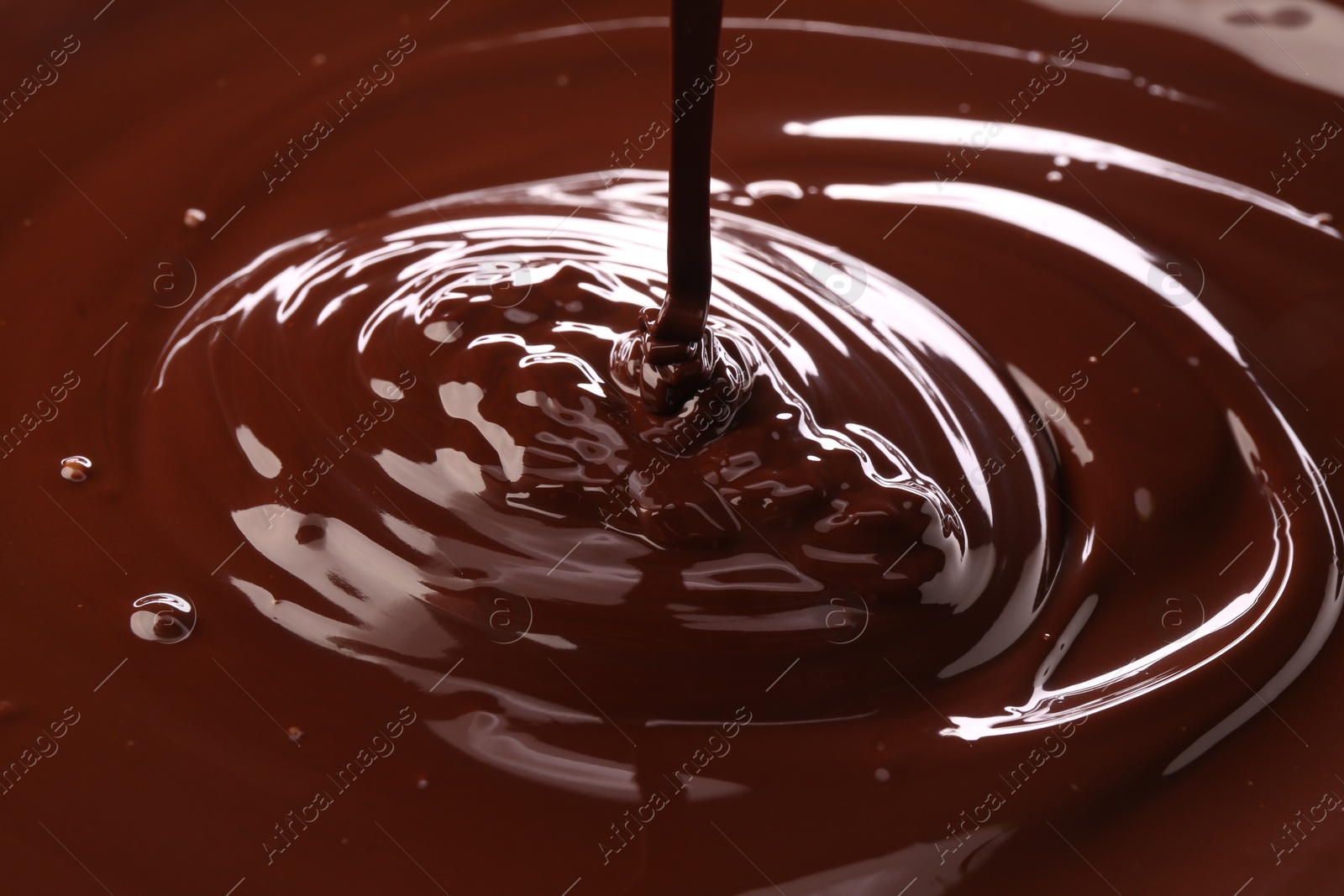 Photo of Closeup view of pouring delicious melted chocolate