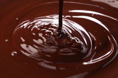 Photo of Closeup view of pouring delicious melted chocolate