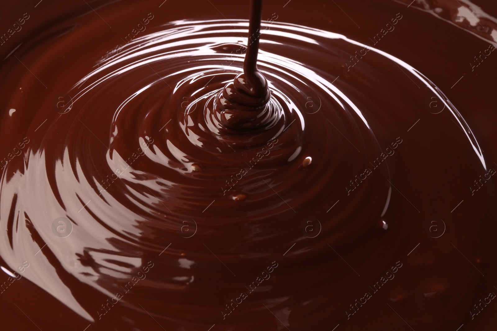 Photo of Closeup view of pouring delicious melted chocolate