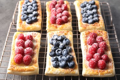 Photo of Tasty puff pastries with berries on grey table, closeup