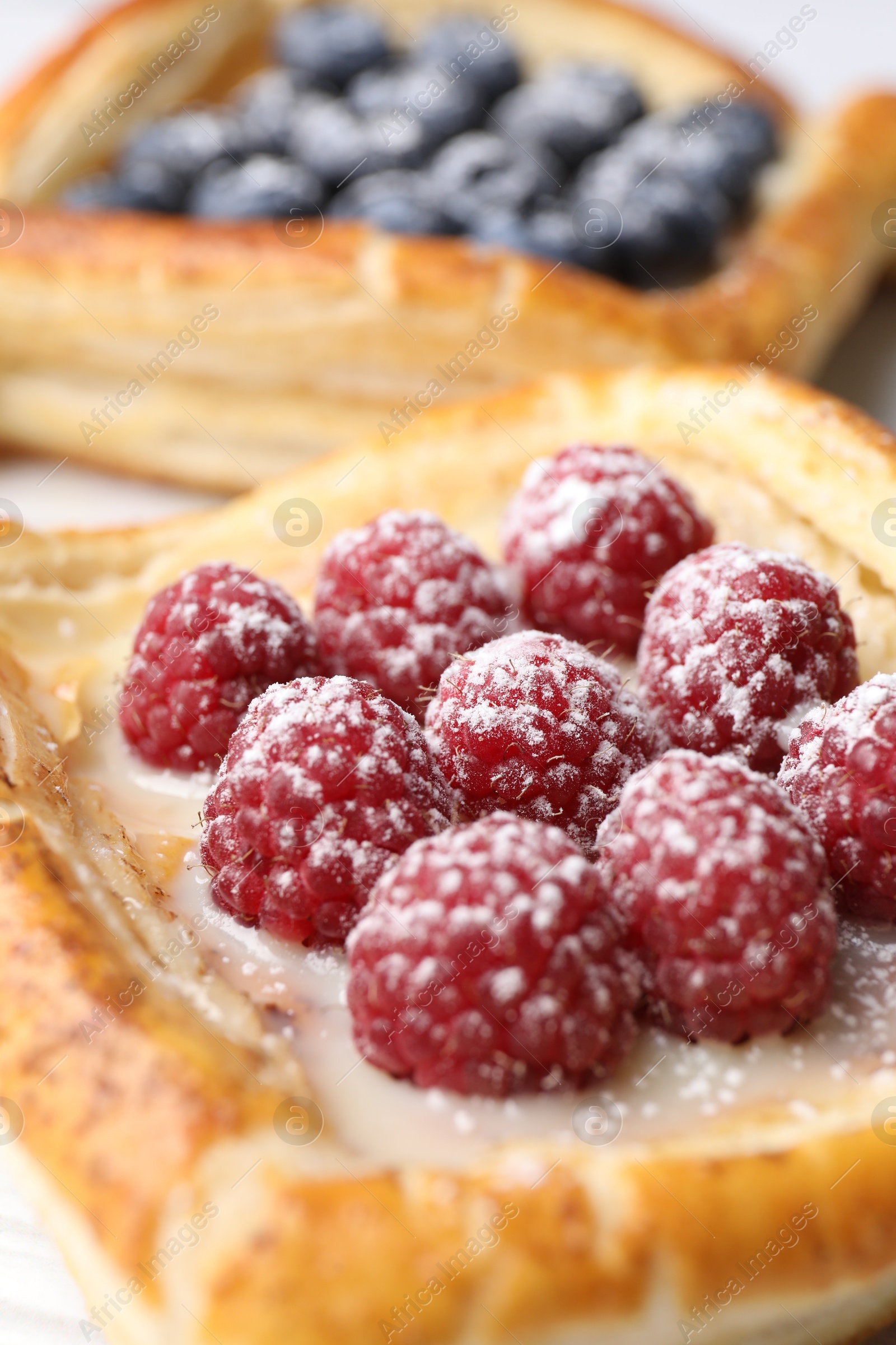 Photo of Tasty puff pastries with berries on table, closeup