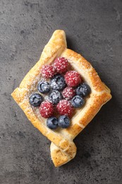 Photo of Tasty puff pastry with berries on grey table, top view