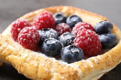 Tasty puff pastry with berries on grey table, closeup