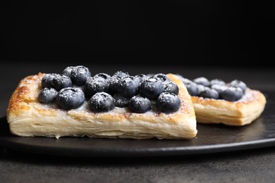 Photo of Tasty puff pastries with blueberries on grey table, closeup