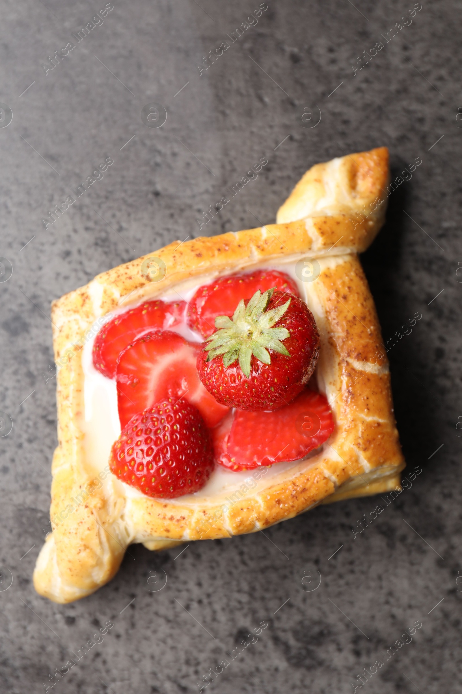 Photo of Tasty puff pastry with strawberries on grey table, top view