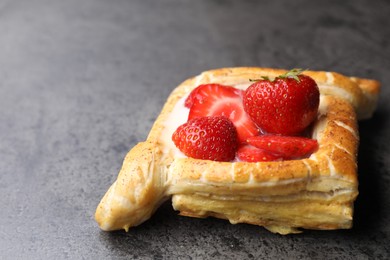 Tasty puff pastry with strawberries on grey table, closeup