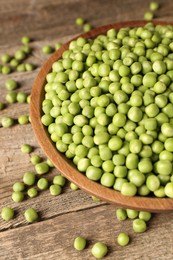 Photo of Fresh green peas in bowl on wooden table, closeup