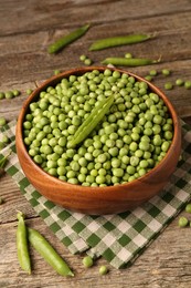 Photo of Fresh green peas and pods on wooden table