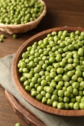 Photo of Fresh green peas in bowl on wooden table, closeup