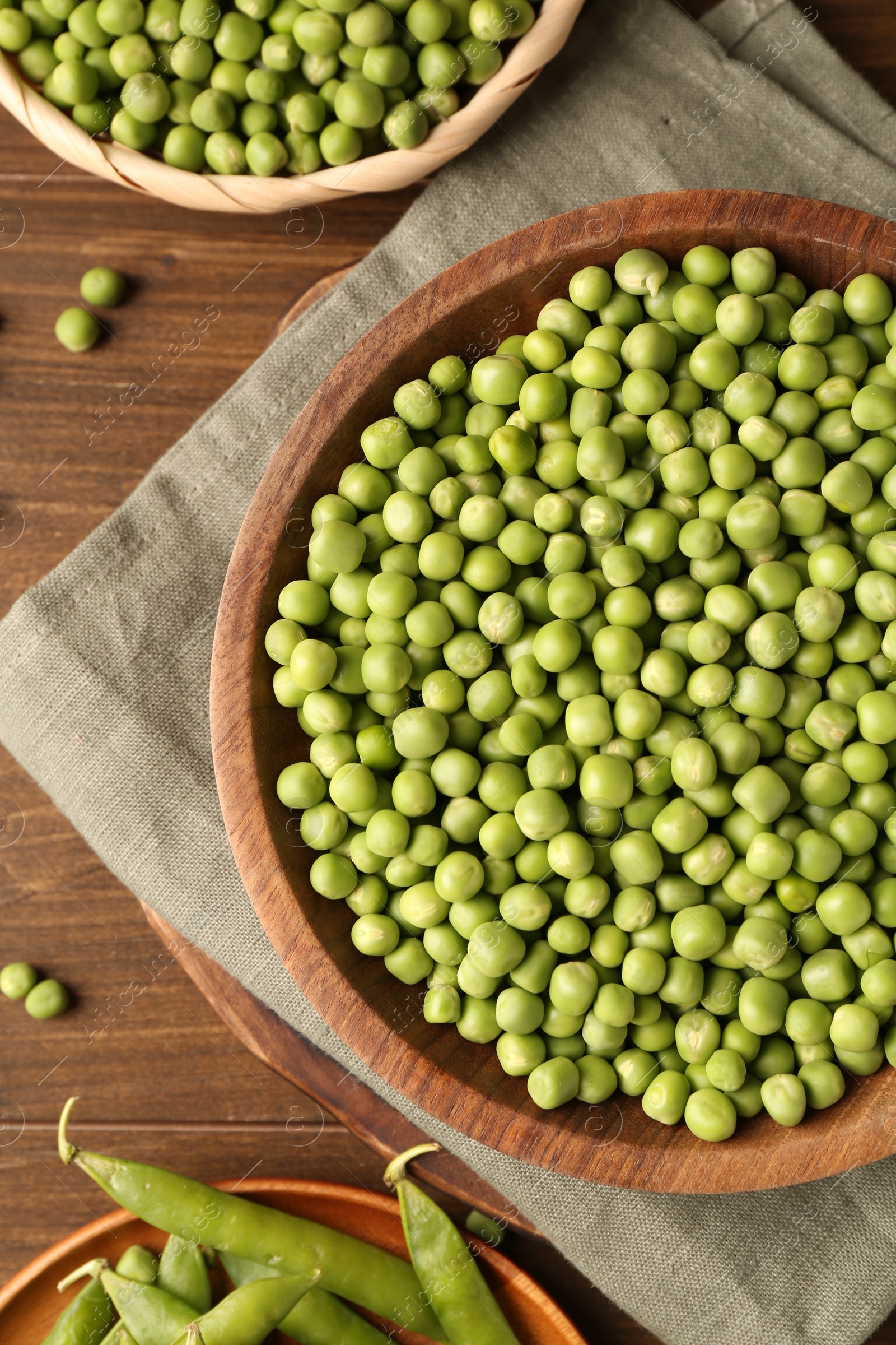 Photo of Fresh green peas and pods on wooden table, flat lay