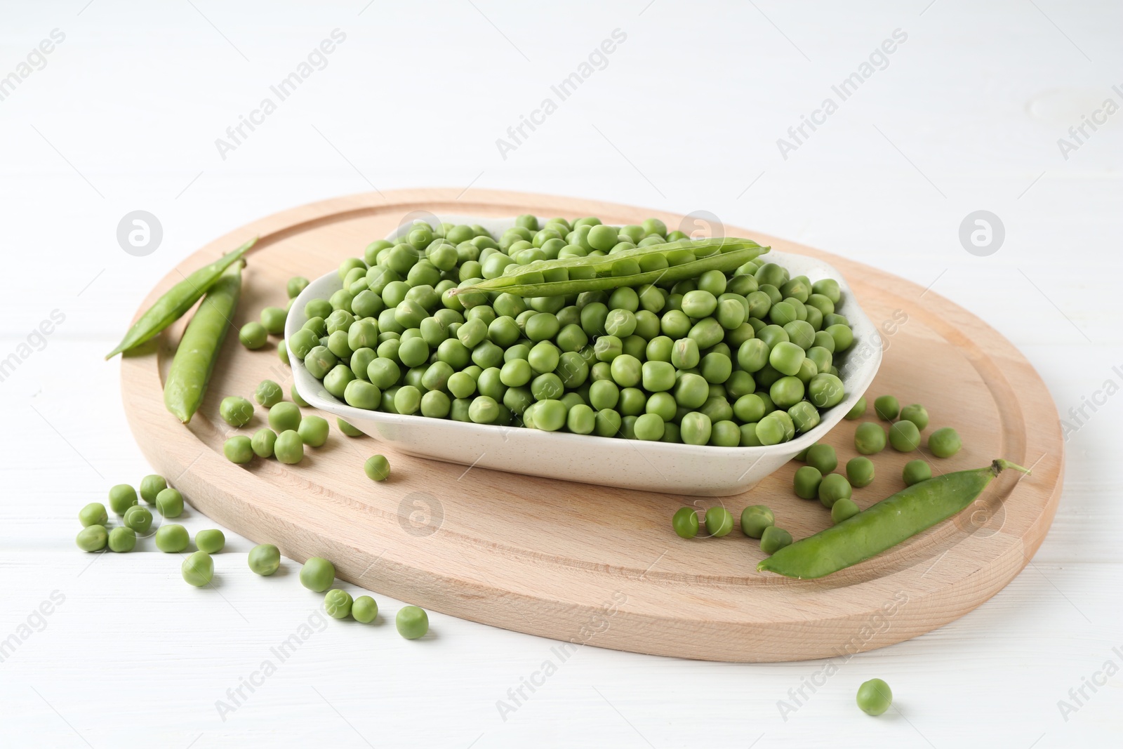 Photo of Fresh green peas and pods on white table