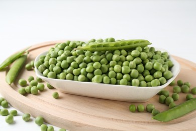 Photo of Fresh green peas and pods on white table