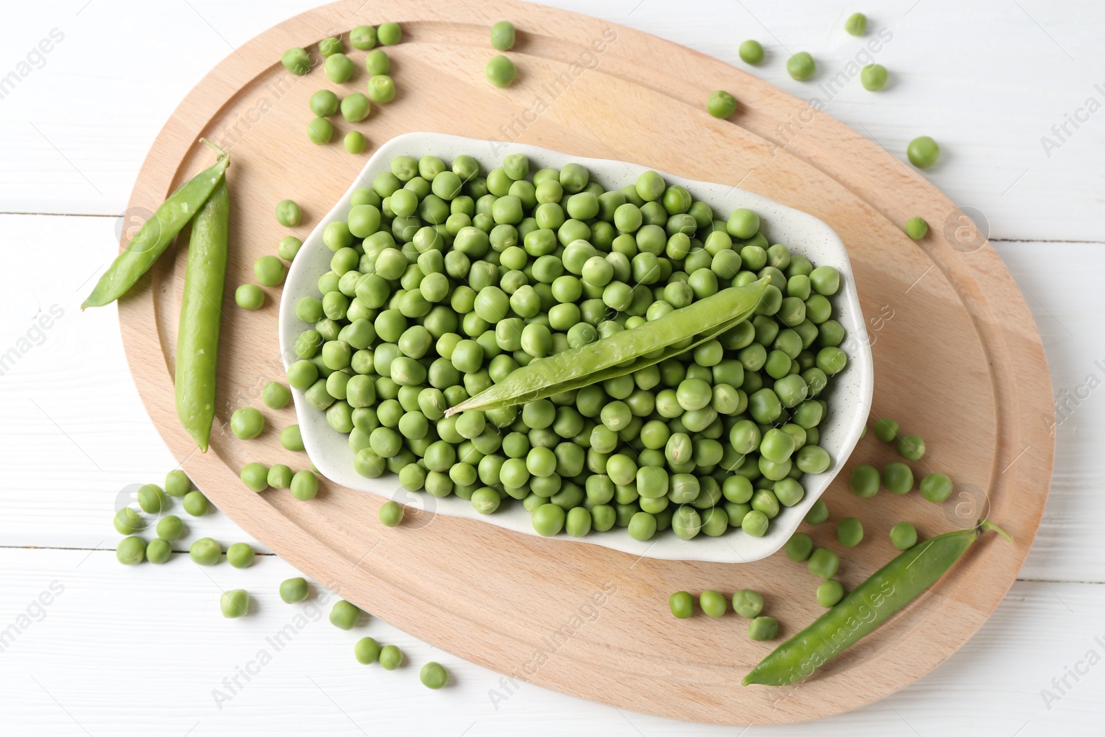 Photo of Fresh green peas and pods on white wooden table, flat lay