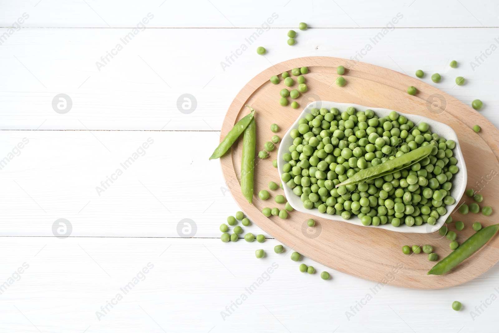 Photo of Fresh green peas and pods on white wooden table, flat lay. Space for text