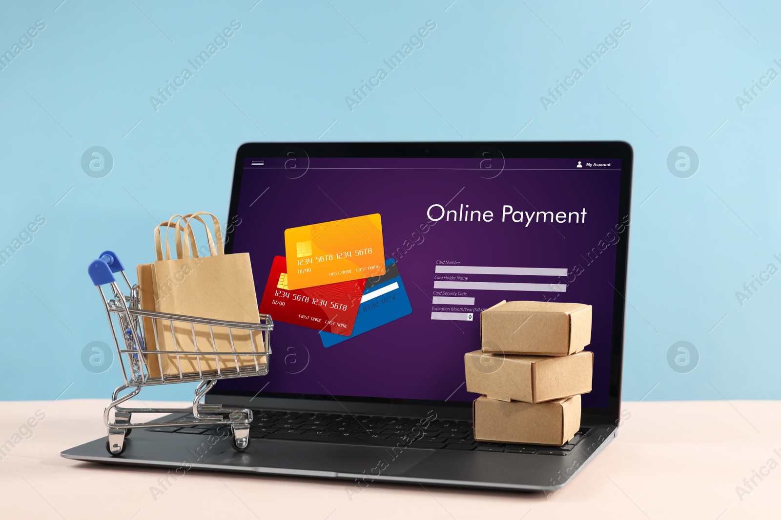 Image of Online payment system. Laptop with open application and small parcels on table